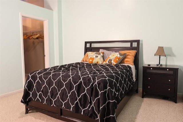 bedroom with carpet floors, a spacious closet, baseboards, and a closet