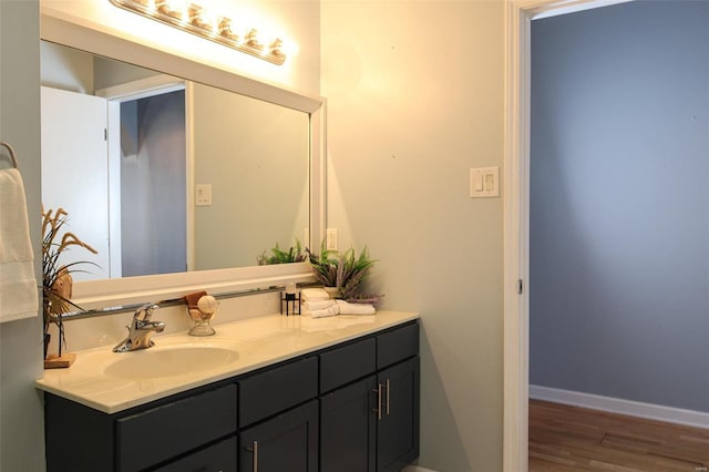 bathroom featuring vanity, baseboards, and wood finished floors