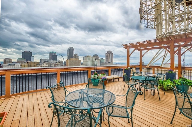 wooden deck featuring outdoor dining space, a city view, and a pergola