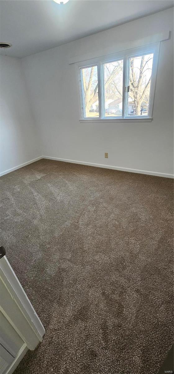 empty room featuring visible vents, baseboards, and carpet floors