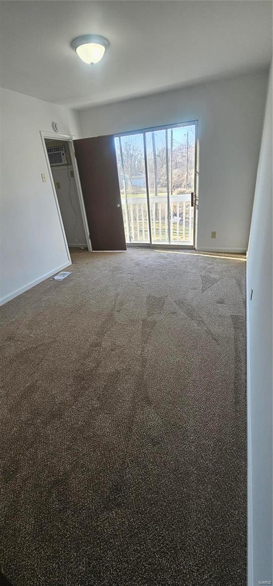 carpeted spare room featuring baseboards