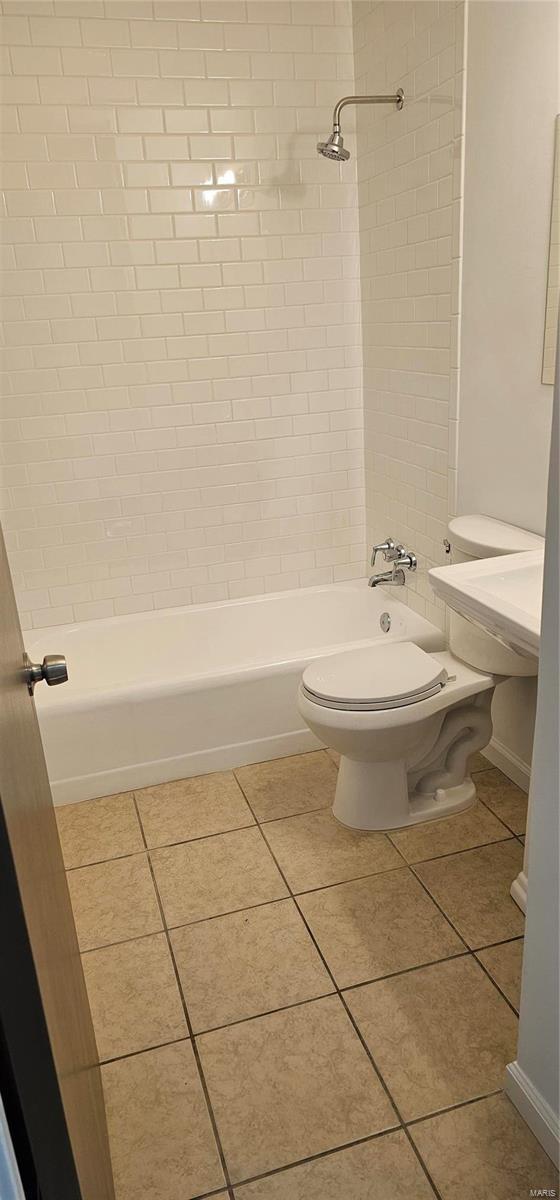 bathroom featuring tile patterned floors, baseboards, toilet, and bathtub / shower combination