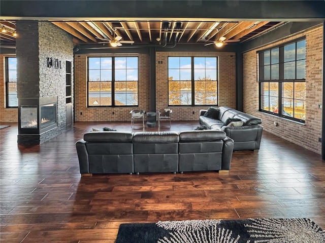 living area featuring plenty of natural light, brick wall, and wood finished floors