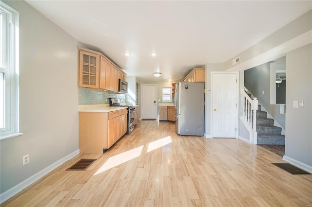 kitchen with light countertops, light wood-style flooring, visible vents, and appliances with stainless steel finishes