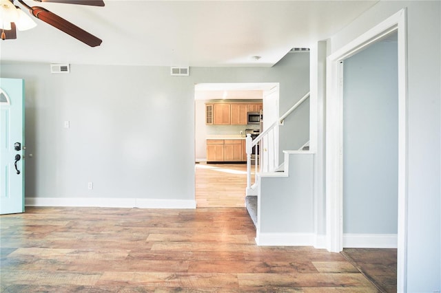 entrance foyer with visible vents, stairs, light wood-type flooring, and baseboards