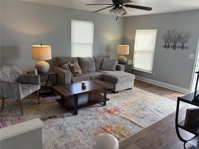 living room with a ceiling fan, baseboards, and wood finished floors