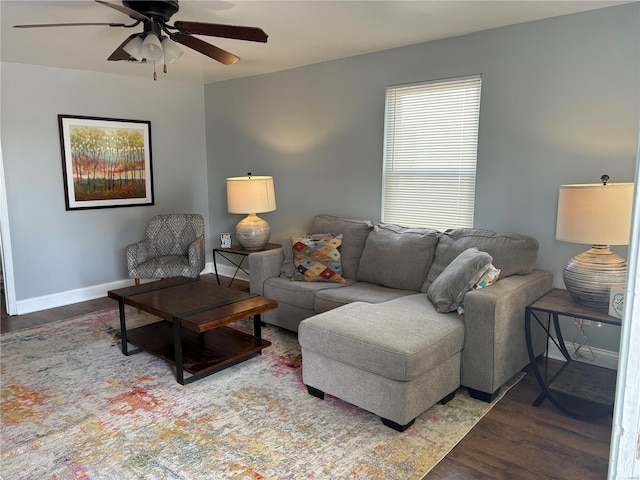 living room featuring ceiling fan, baseboards, and wood finished floors