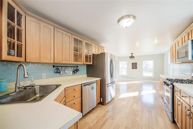 kitchen featuring backsplash, appliances with stainless steel finishes, and a sink