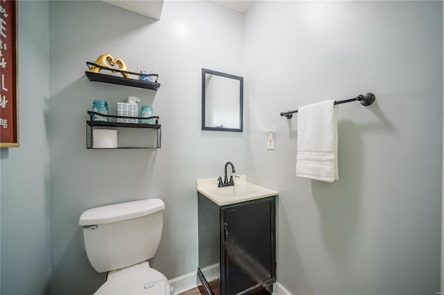 bathroom featuring baseboards, toilet, and vanity