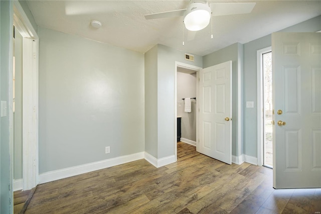 unfurnished bedroom with visible vents, ceiling fan, baseboards, and wood finished floors