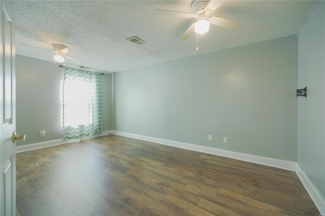 empty room featuring visible vents, a textured ceiling, wood finished floors, baseboards, and ceiling fan