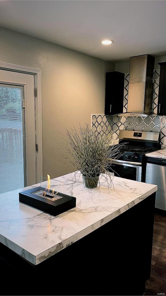 kitchen featuring tasteful backsplash, appliances with stainless steel finishes, dark cabinetry, and light countertops