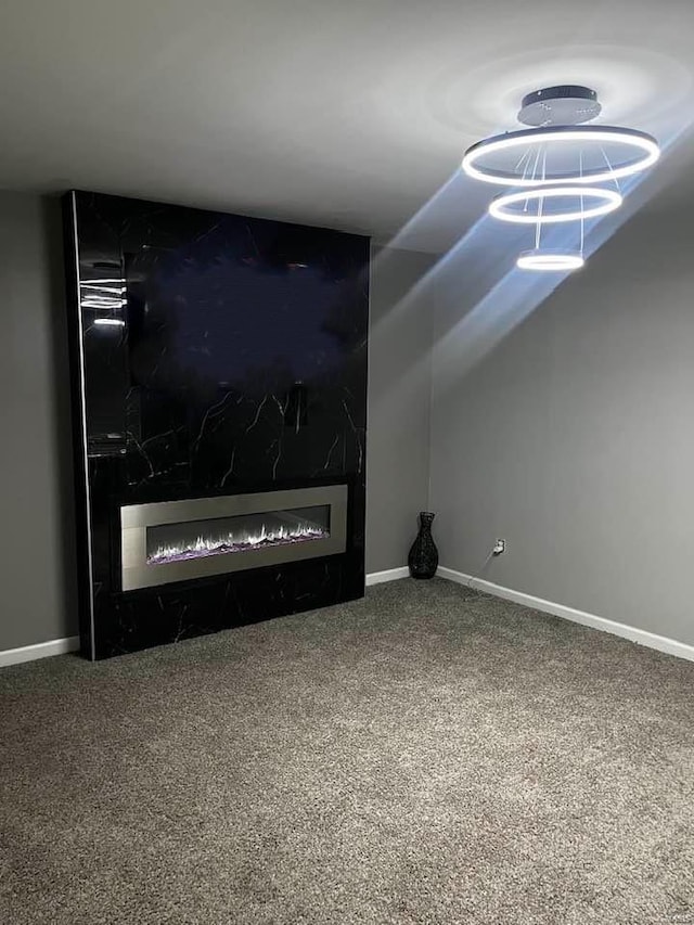 unfurnished living room featuring baseboards, carpet floors, and a large fireplace