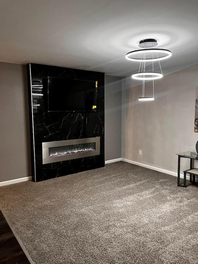 carpeted living room featuring baseboards and a fireplace