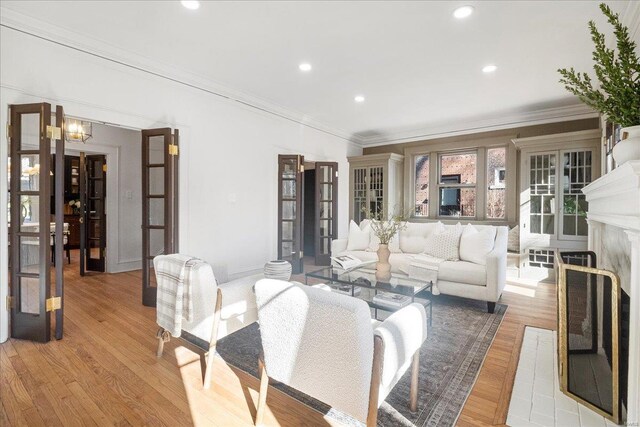 living area with recessed lighting, light wood-style floors, and ornamental molding