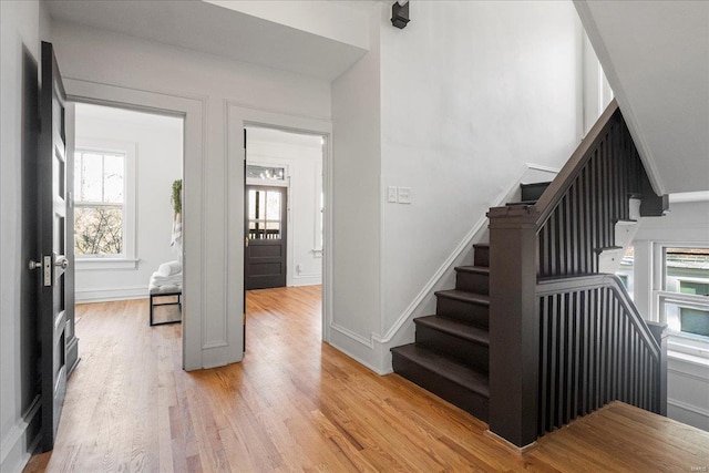 stairway with wood finished floors and baseboards