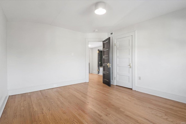 empty room featuring light wood-style floors and baseboards