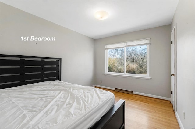 bedroom featuring visible vents, baseboards, and wood finished floors