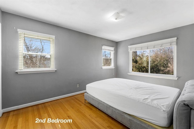 bedroom with baseboards and wood finished floors