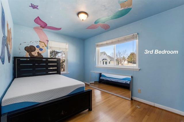 bedroom featuring wood finished floors and baseboards