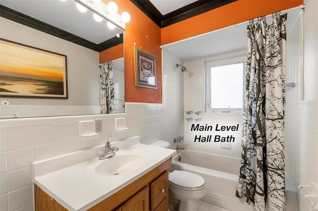 bathroom with tile walls, toilet, shower / tub combo, wainscoting, and vanity