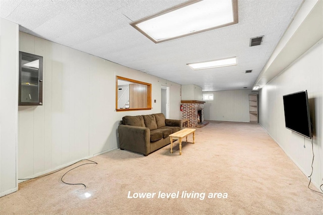 carpeted living area with a textured ceiling, a brick fireplace, and visible vents