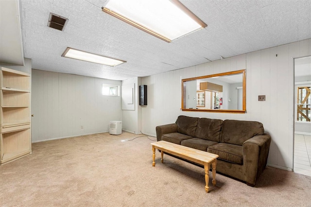 carpeted living room featuring a wealth of natural light, visible vents, and a textured ceiling