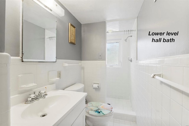 full bathroom featuring toilet, a shower stall, tile walls, and vanity