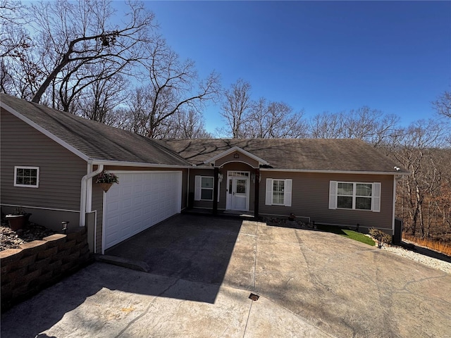 ranch-style house with an attached garage, driveway, and roof with shingles