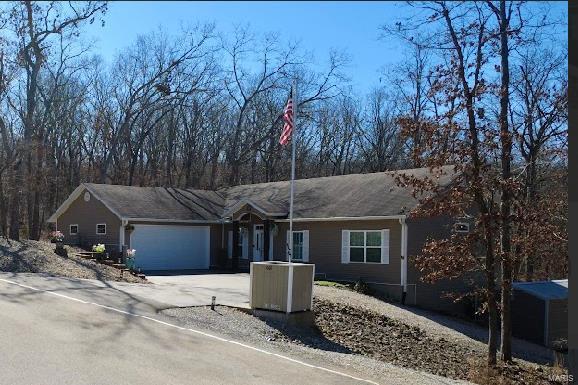 ranch-style house with a garage, aphalt driveway, and cooling unit