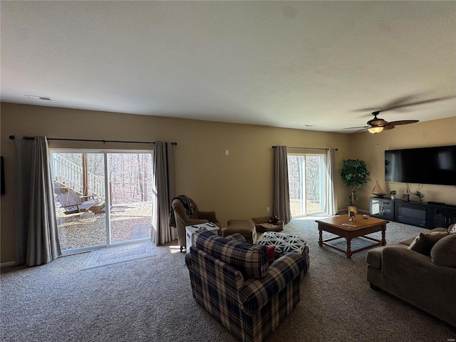 carpeted living area featuring ceiling fan and visible vents