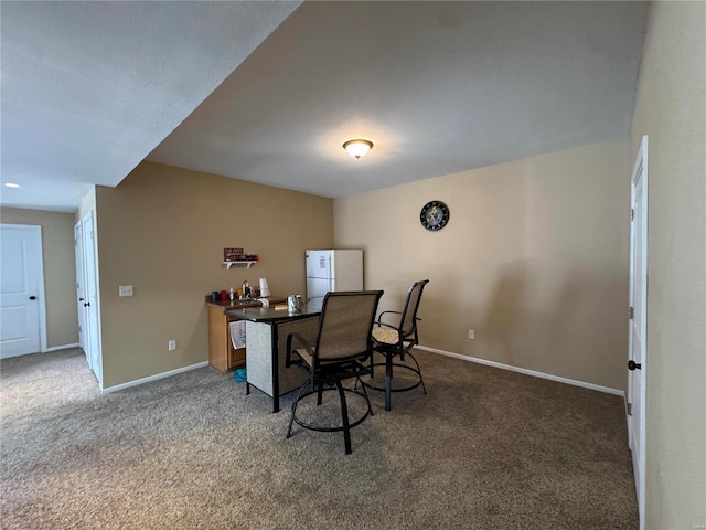 carpeted office featuring baseboards