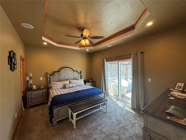 bedroom with a textured ceiling, carpet floors, a ceiling fan, access to outside, and a raised ceiling