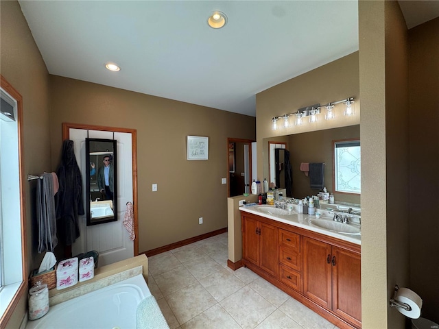 bathroom with double vanity, baseboards, tile patterned floors, a sink, and a bath