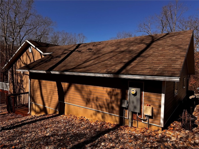 view of side of home featuring roof with shingles