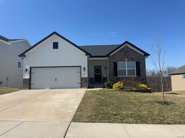 ranch-style house with a front yard, concrete driveway, brick siding, and an attached garage