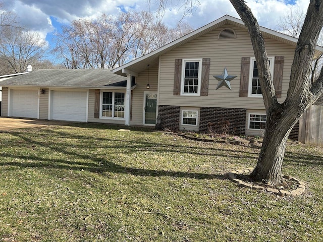 tri-level home featuring a garage, driveway, a front lawn, and fence