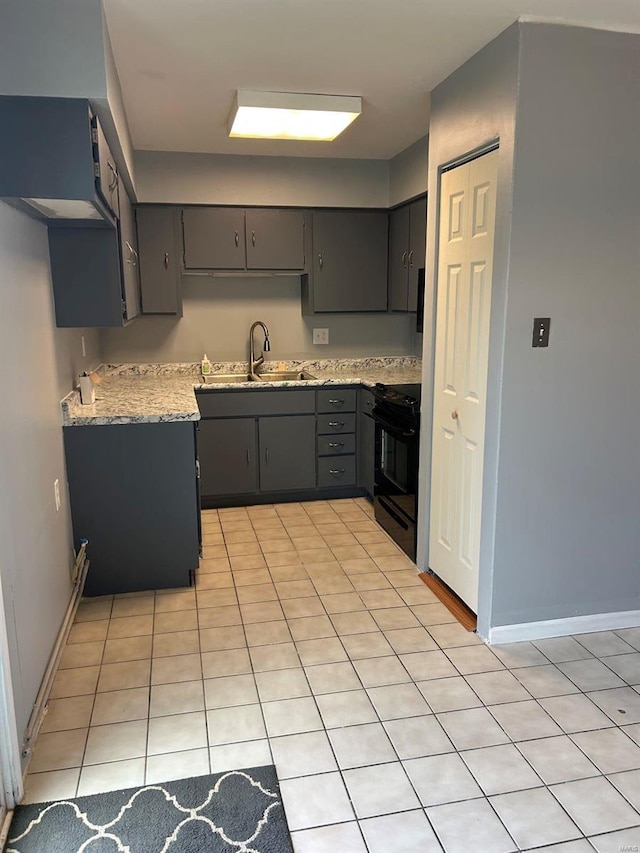 kitchen with black gas stove, light tile patterned floors, gray cabinets, and a sink