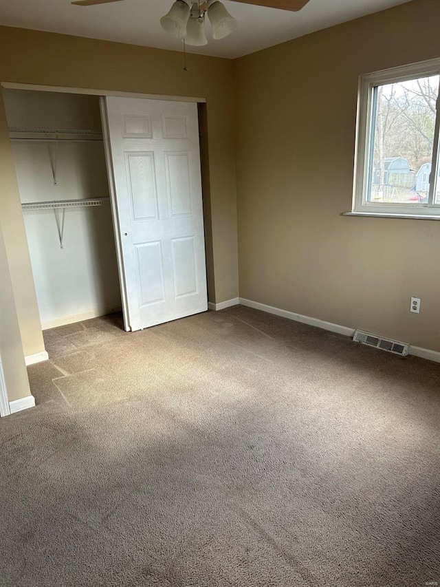 unfurnished bedroom with a closet, visible vents, baseboards, and carpet