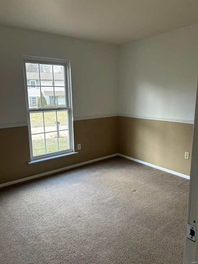 carpeted spare room featuring baseboards