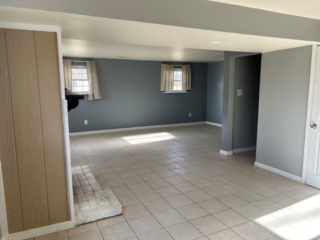 spare room with light tile patterned flooring, plenty of natural light, and baseboards