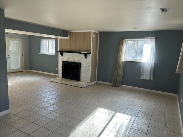 unfurnished living room with light tile patterned floors, visible vents, baseboards, and a brick fireplace