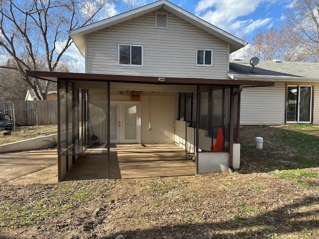 back of property featuring fence and a sunroom