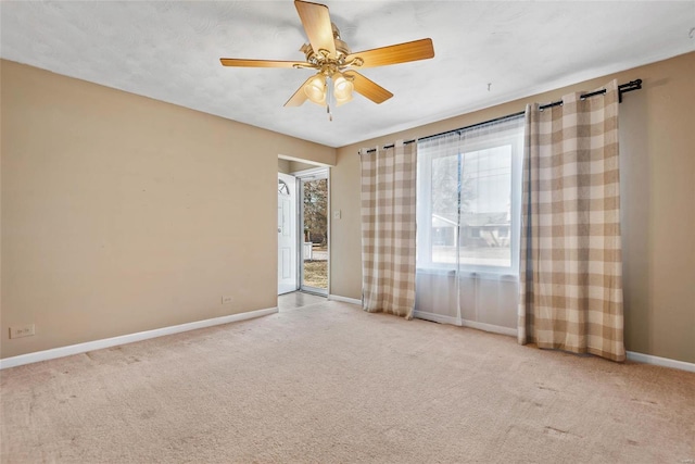 spare room featuring ceiling fan, baseboards, and carpet