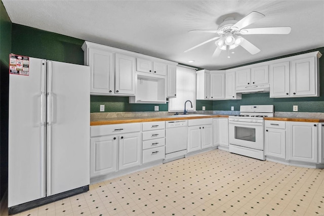 kitchen featuring under cabinet range hood, white cabinets, white appliances, and a sink