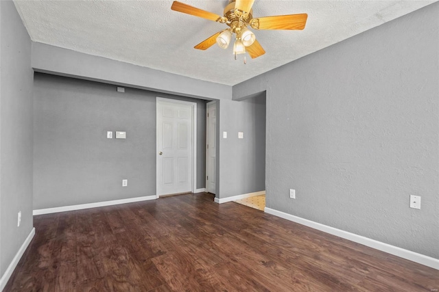 spare room with baseboards, wood finished floors, a textured wall, a textured ceiling, and a ceiling fan