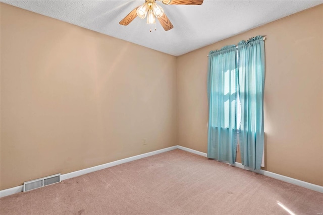 spare room with visible vents, baseboards, a ceiling fan, and carpet floors