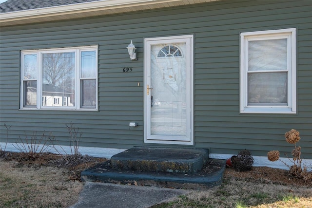 entrance to property with roof with shingles