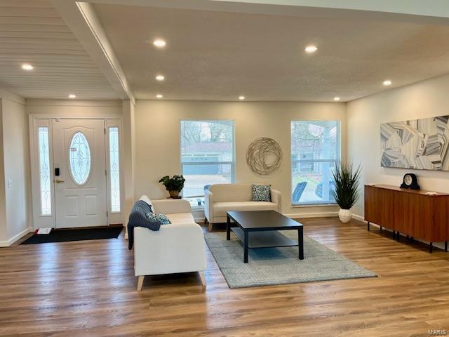 living area featuring recessed lighting, baseboards, and wood finished floors