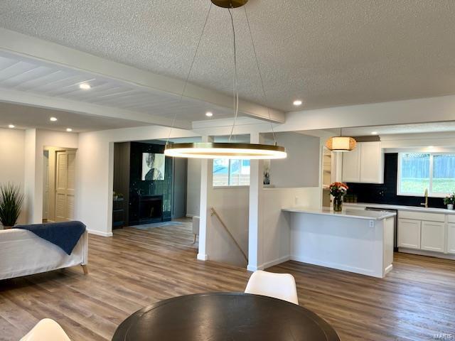 living room with a wealth of natural light, beamed ceiling, and wood finished floors